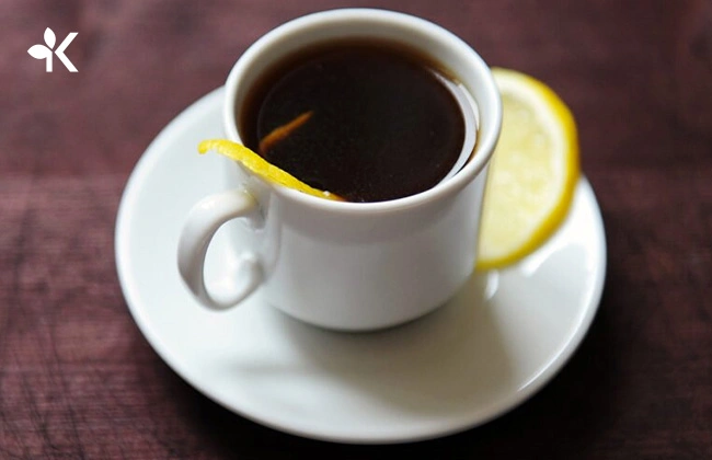 Taza blanca con café romano y una rodaja de limón